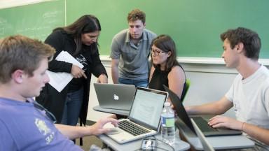 Prof. Mary Lopez talks with her students in the classroom