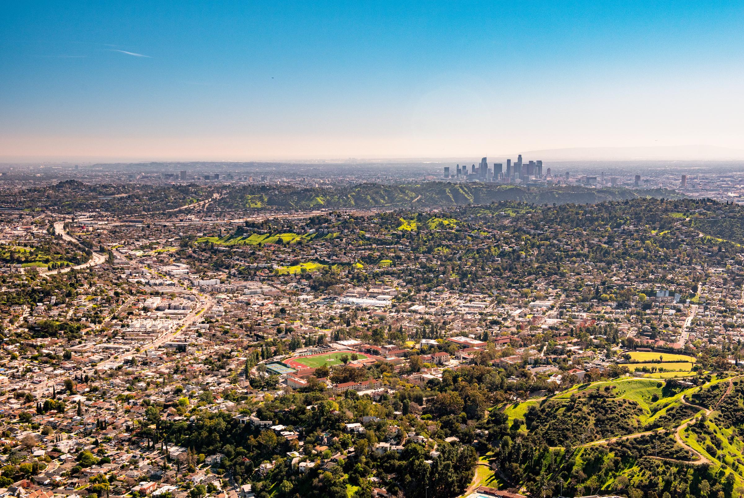 A view of campus from a drone with downtown LA in the background