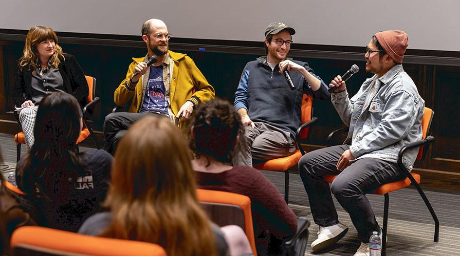 Four filmmakers sit on stage in a panel with microphones