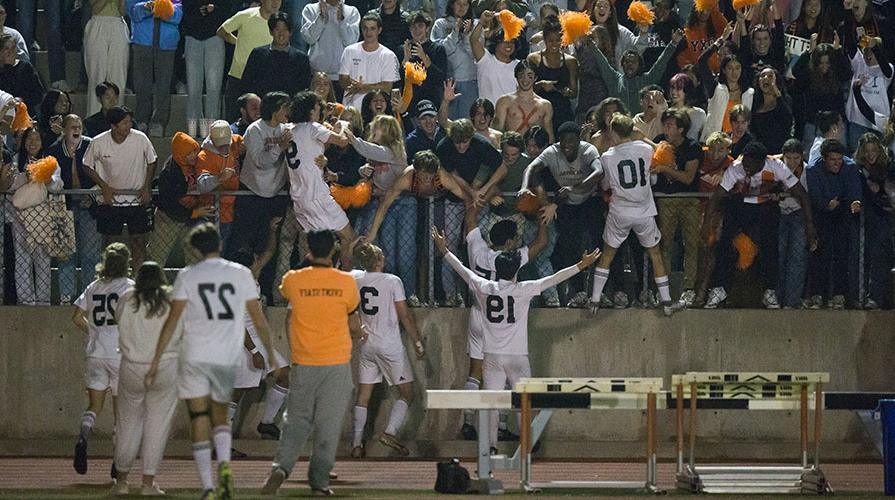 Soccer players approach the fans in the stands joyfully after their win