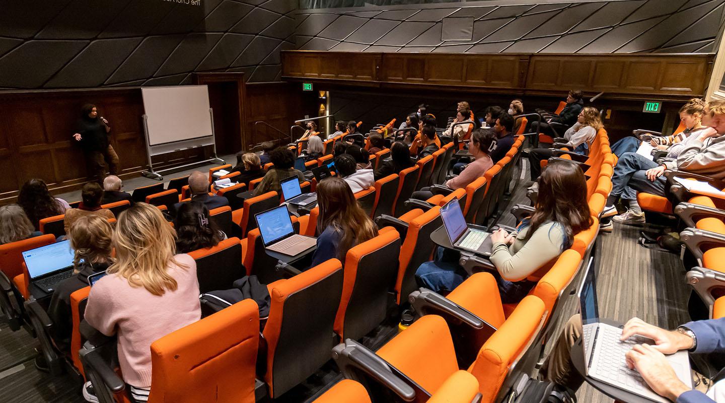 Choi Auditorium filled with people and a guest speaker up front