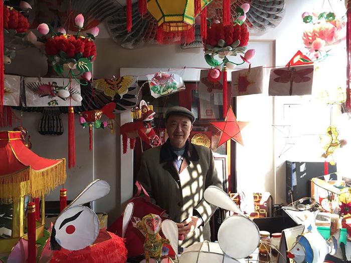 Man surrounded by handmade Chinese lanterns