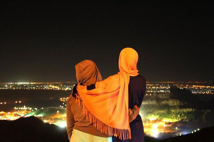 Two women looking over the night landscape of Al Ain