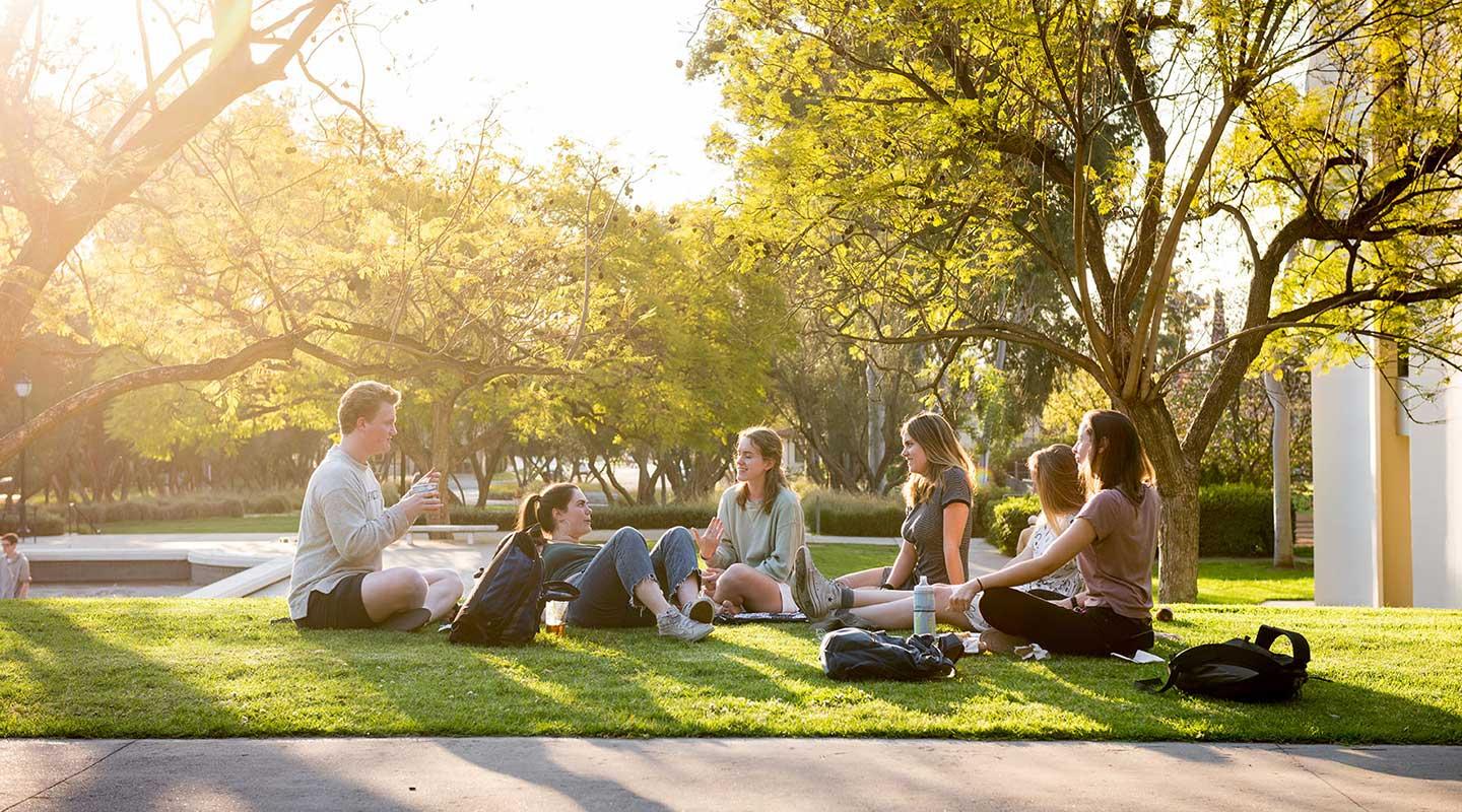 学生s hanging out on the grass on campus