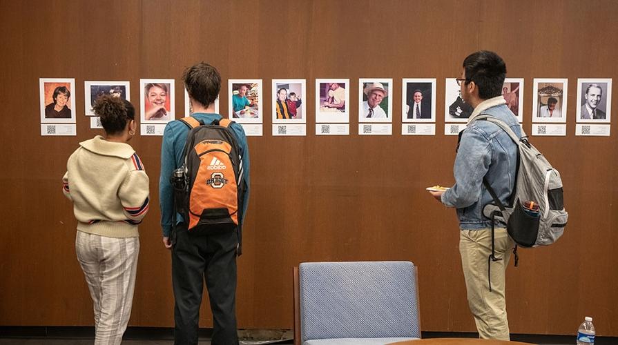 Students looking at student work on the walls in the library