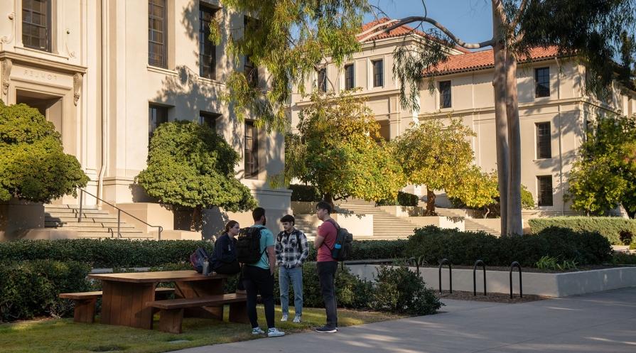 students standing in front of Fowler Hall, talking