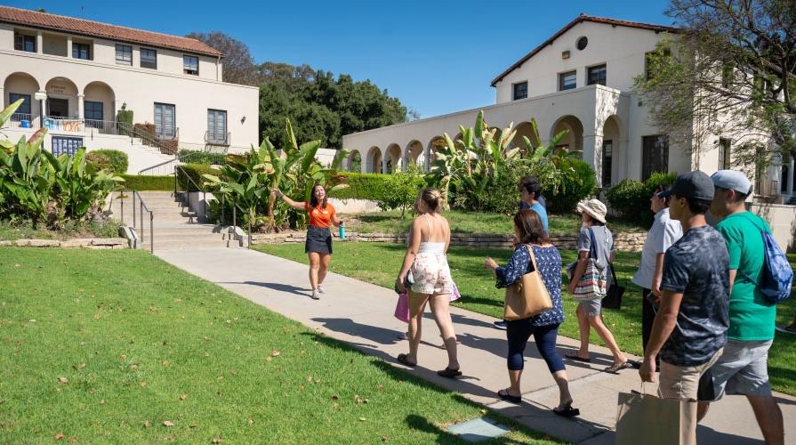 a student tour guide leads visitors around the Occidental College campus