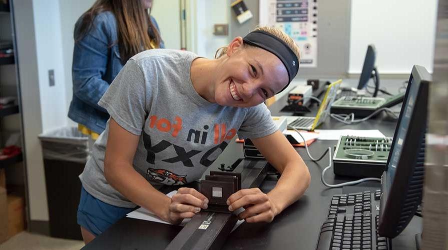 A smiling student working in the physics lab