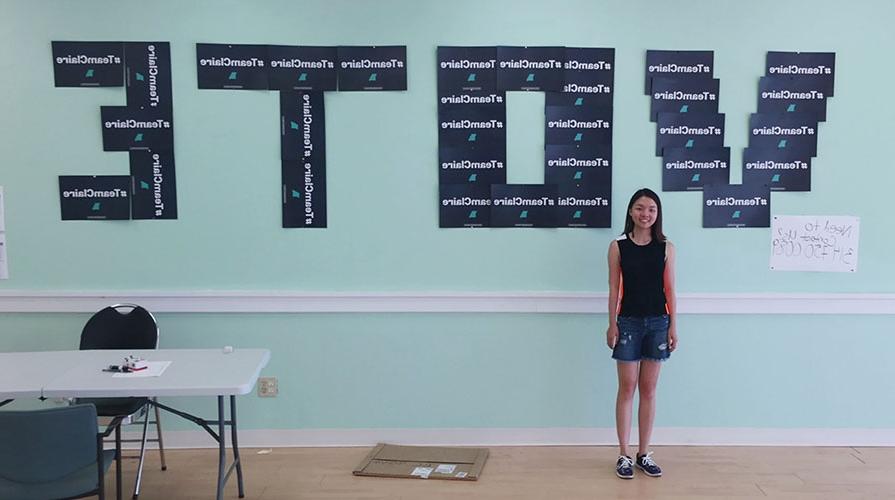 Student stands in front of wall decorated with campaign signs