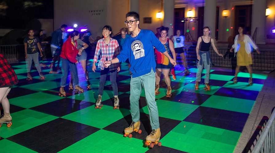 Students rollerskating on the pavement in front of Thorne Hall