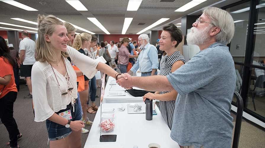 A professor talks to a student at Orientation