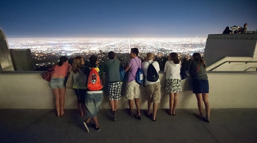 Students look over the lights of 洛杉矶 at night from the Griffith Park Observatory