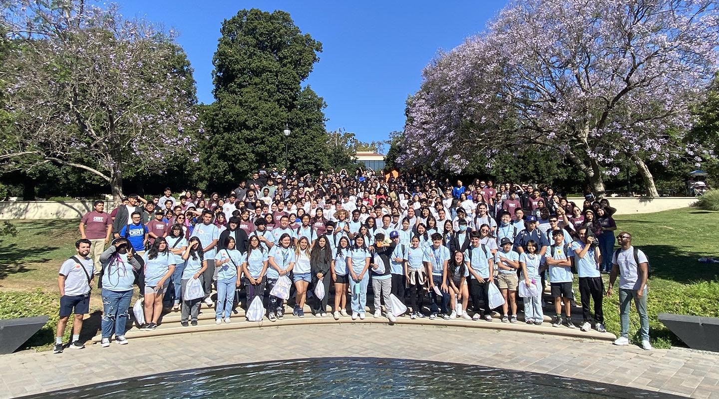 A large group of Upward Bound students pose on the steps by Gilman Fountain on campus