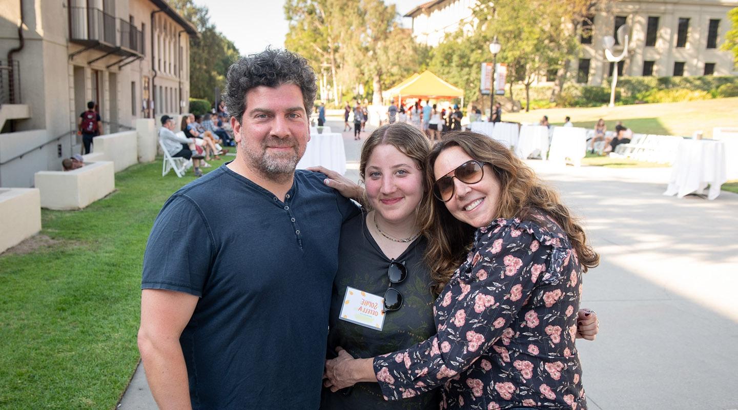 A student embracing her parents