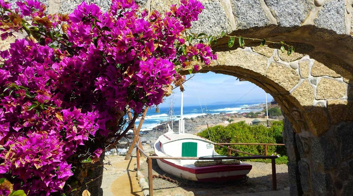 A sailboat on a beach next to the ocean