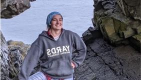 Person in front of rocks and ocean