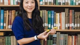 Whitney Tsai Nakashima in front of bookshelf holding birds