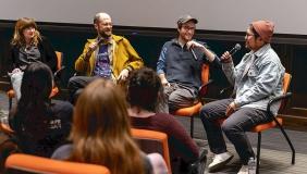 Four filmmakers sit on stage in a panel with microphones