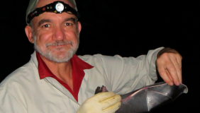 Dr. Rodrigo A. Medellín holding a bat