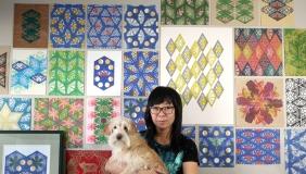 Jennifer Zee holding dog in front of art