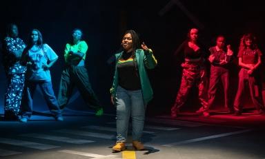 students in hip-hop clothing stand in a formation on the Keck Theater stage