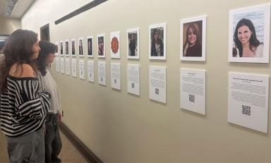 Spectators view the OCLAA oral history gallery in the Academic Commons in February 2024.