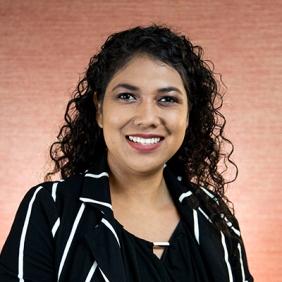 Cecilia Garibay is smiling and wearing a black and white striped shirt