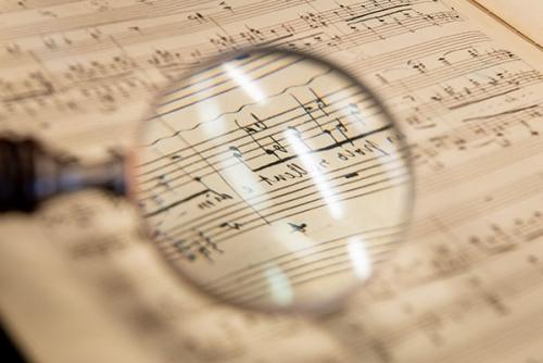 A 音乐al manuscript of Franz Liszt with a magnifying glass in the foreground